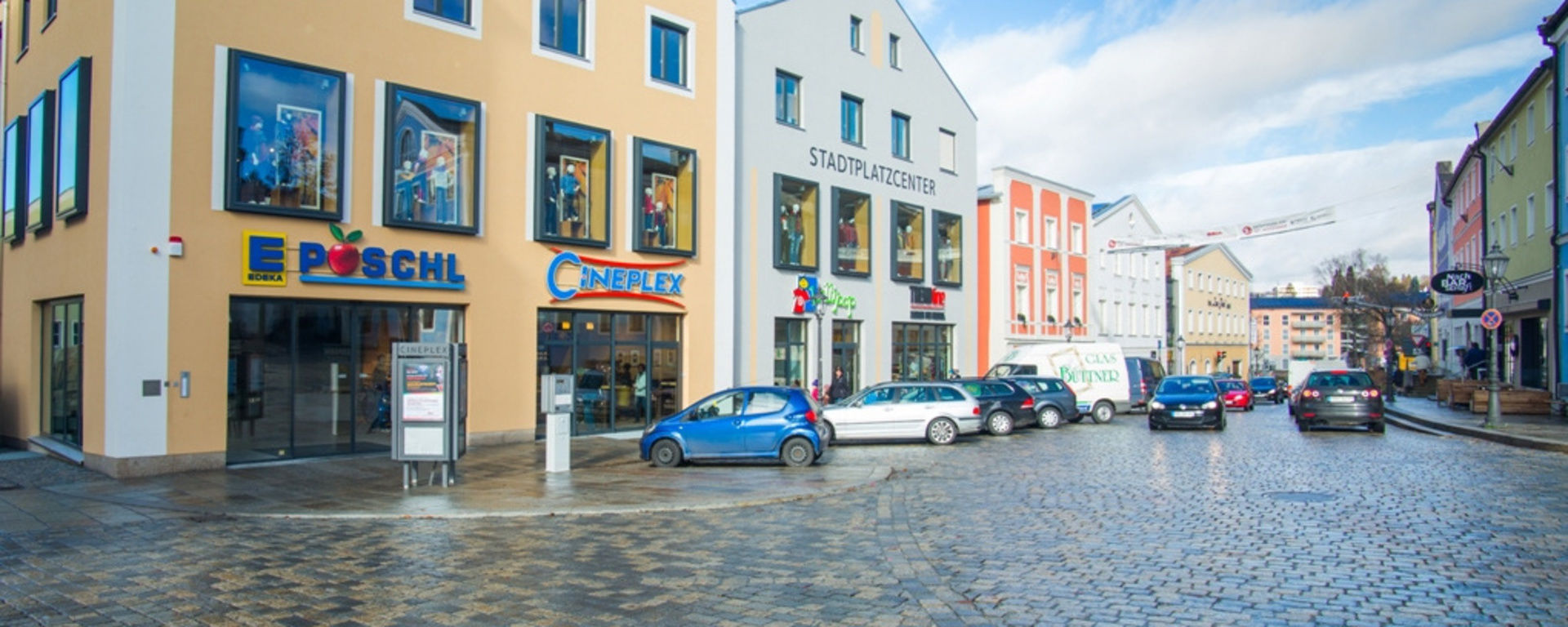 Stadplatz Freyung mit vielen Autos und großen Geschäften und dem Kino