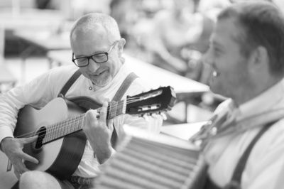 Musiker mit Gitarre beim Musizieren und lachen