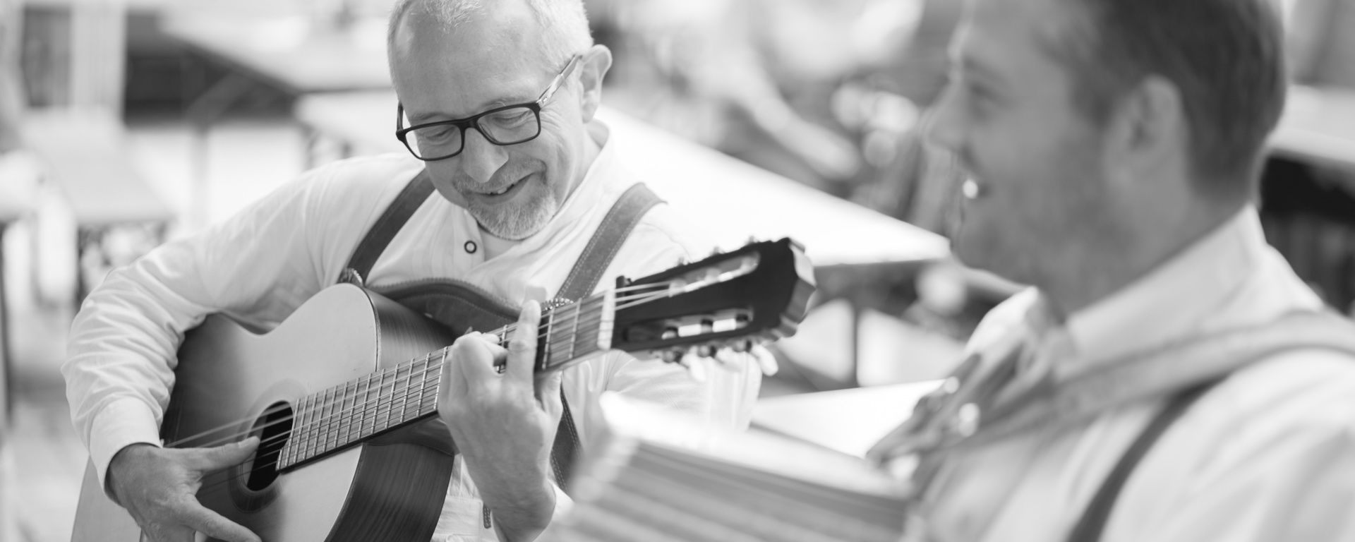 Musiker mit Gitarre beim Musizieren und lachen