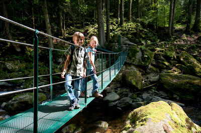 Kinder auf einer Brücke über vielen Steinen