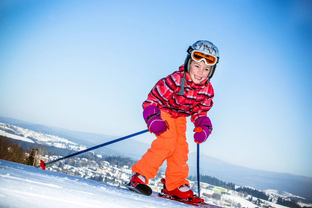 Kleines Mädchen bei den ersten Skiübungen