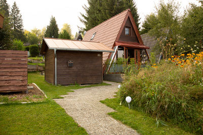 Kleines Häuschen mit grünem Garten und vielen Pflanzen