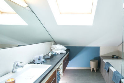 Modernes Badezimmer mit Dachschräge und großem Spiegel