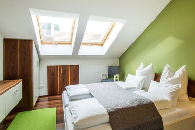 Modernes Schlafzimmer mit Dachschräge und großem Bett