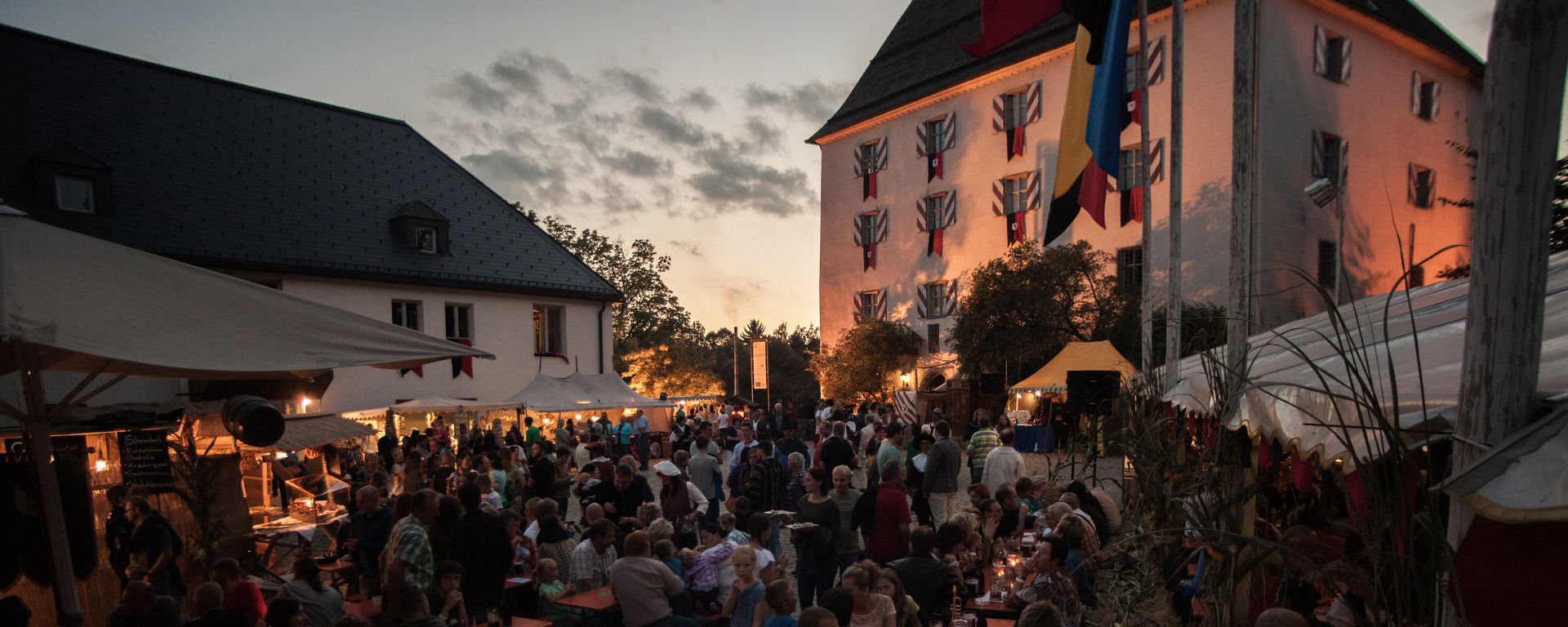 Gesellige Menschen auf Bierbänken bei einem Ritterfest