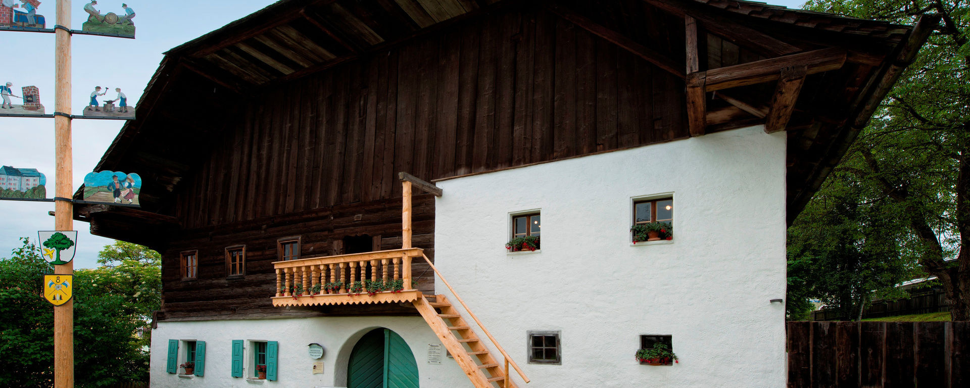 Heimatmuseum Bauernhaus altes Haus mit Holztreppe und einem kleinen Maibaum davo