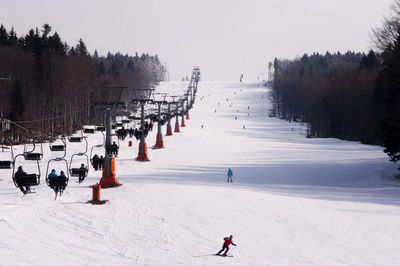 Skilift mit vielen Skifahrern auf einer großen Piste